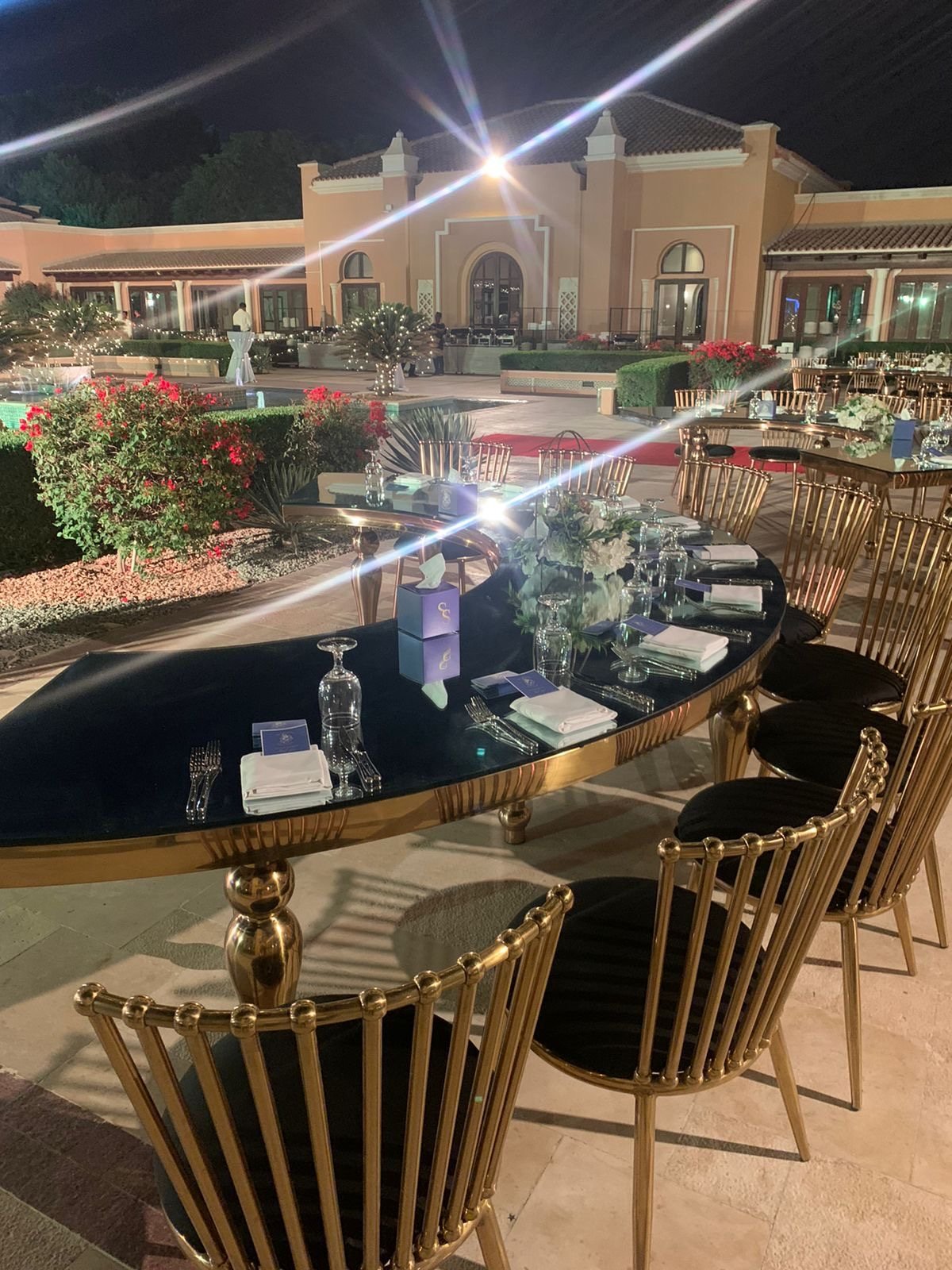 Gold and black oval table with gold chairs, outdoors