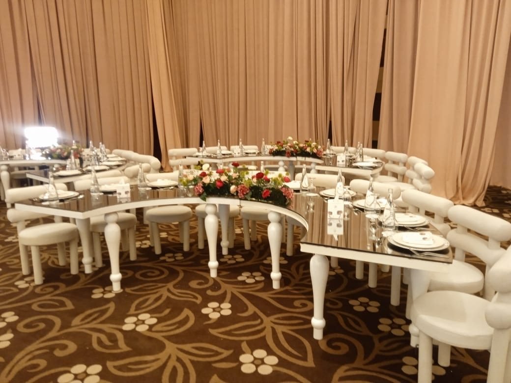Curved mirror-top tables with white seating